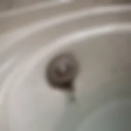A close-up view of a bathtub drain with visible debris and buildup